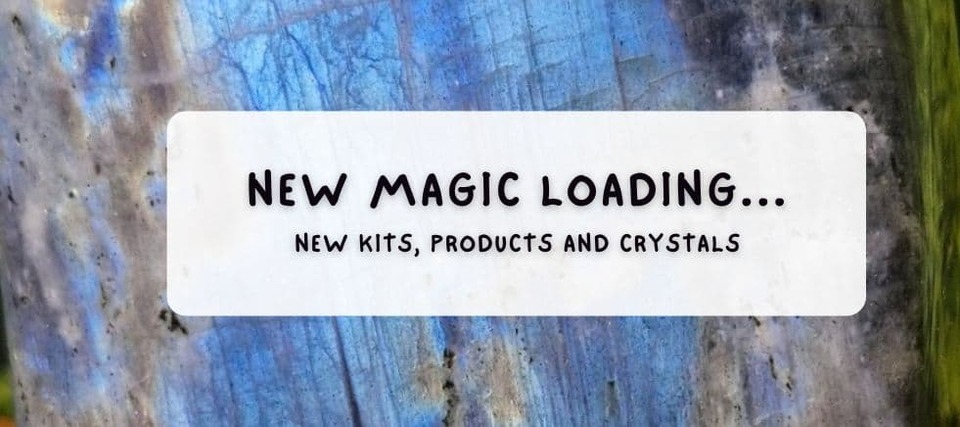 Text overlay on a shimmering labradorite crystal reads “New Magic Loading... New Kits, Products and Crystals,” promoting Sparkle & Spell Co., a New Zealand-based shop offering magical potion kits, DIY potion sets, magick crystals, and handcrafted magical wands.